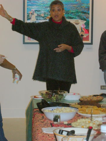 A woman standing in front of a table with food.