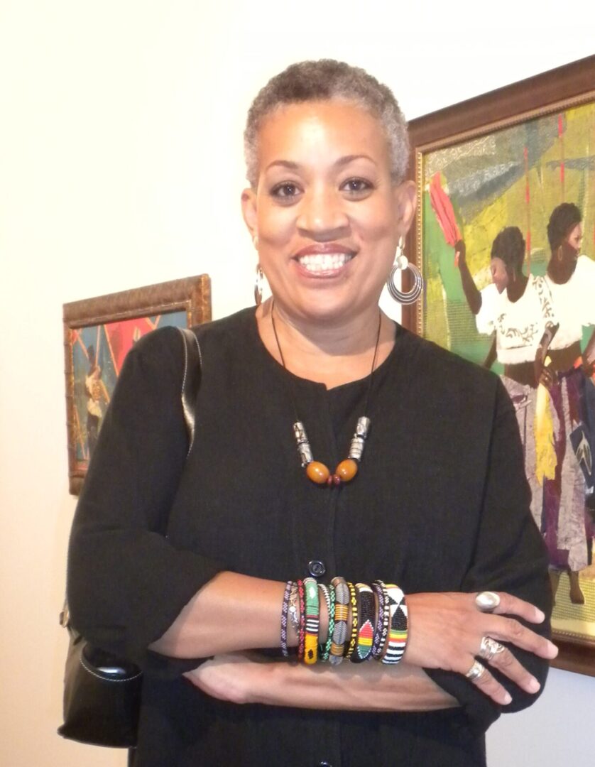 A woman with short hair wearing bracelets and necklaces.
