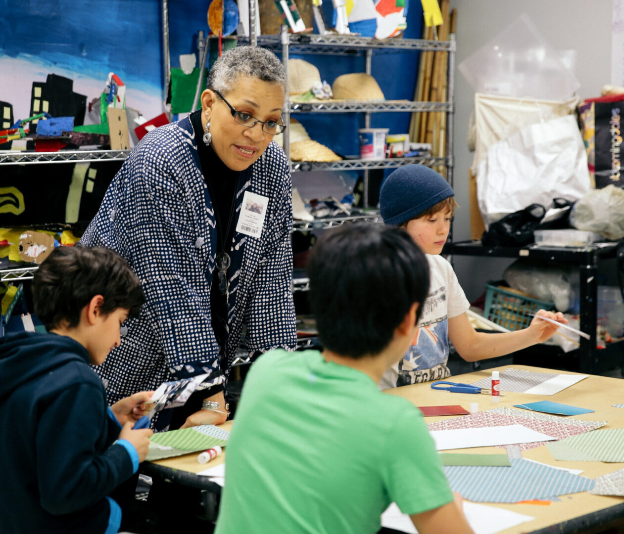 A group of children sitting at tables with papers.