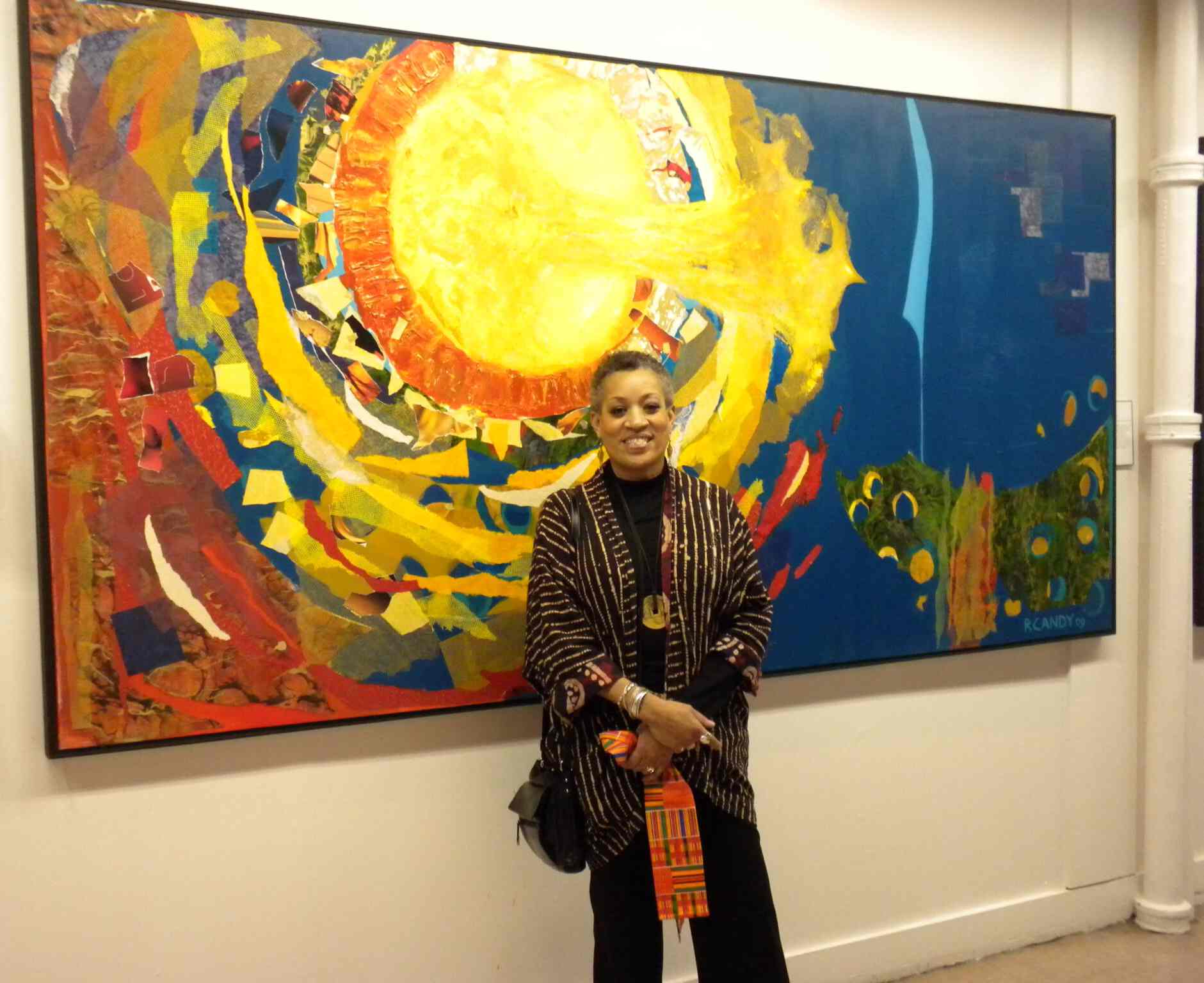 A woman standing in front of two paintings.